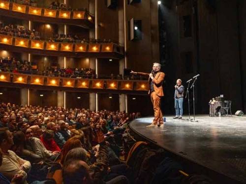 Zwei Männer stehen auf einer Bühne und reden zum Publikum