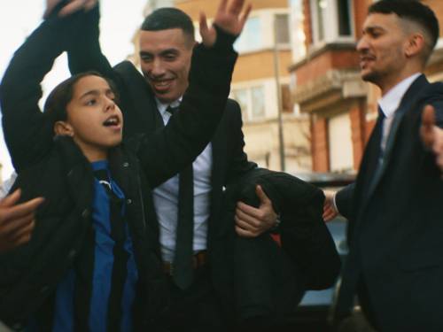 dunkel gekleidete Personen tanzen auf der Straße