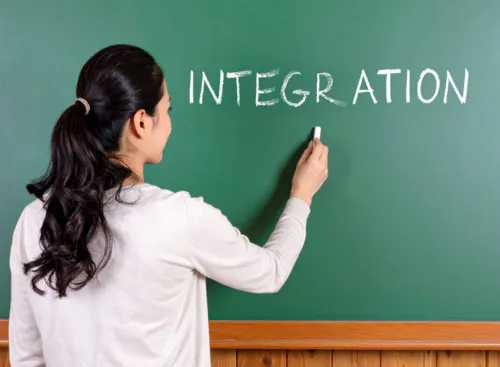 Eine Frau mit schwarzen Haaren schreibt an eine Tafel INTEGRATION