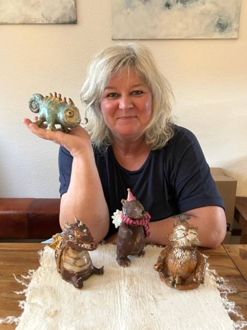 Eine Frau hinter einem Tisch mit Keramik Figuren