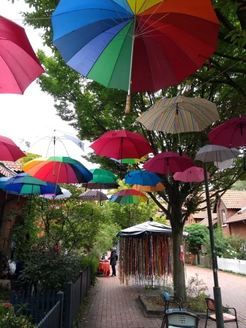 viele, bunte und in der Luft schwebende Regenschirme
