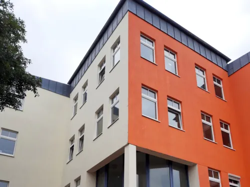 Blick auf den Eingang eines mehrgeschossigen Gebäudes.