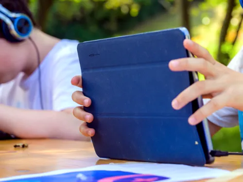 Kinderhände halten einen Tablet-Computer.
