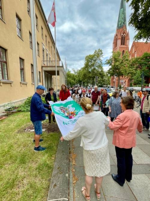 riedenskraniche der Aktion von Steps for Peace tanzen auf der Mayors for Peace Flagge in Berlin Steglitz-Zehlendorf