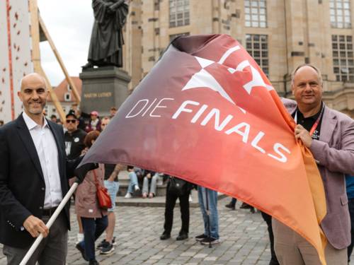 Oberbürgermeister Belit Onay übernimmt die Finals-Flagge von Dresdens Oberbürgermeister Dirk Hilbert.