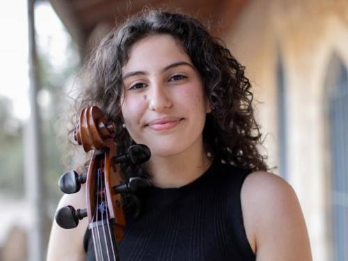 Porträtfoto einer Musikerin vor ihrem Cello.