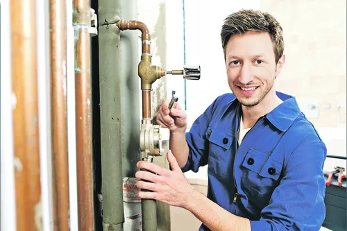 Ein Handwerker stellt die Heizung ein