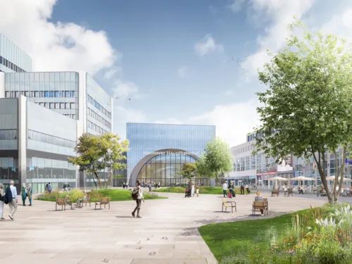 Ein Platz mit Grünfläche und Menschen, teilweise auf Stühlen sitzend. Rechts und links Gebäude, in der Mitte ein Gebäude mit der Aufschrift DB Hauptbahnhof Hannover