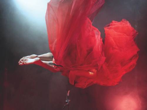 Eine Frau in einem roten Kleid auf einer Bühne