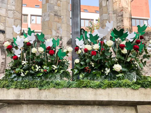 Blumen und Tauben an einer Kirche.