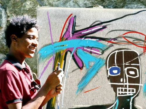 Ein junger Mann steht vor einer besprühten Wand