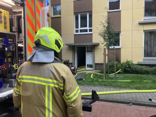 Eine Feuerwehrkraft steht vor einem Haus