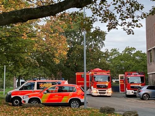 Mehrere Einsatzfahrzeuge der Feuerwehr Hannover stehen vor einer Schule.