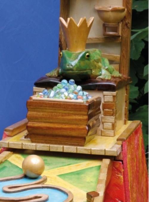 Eine Murmelbahn mit einem Frosch drauf.