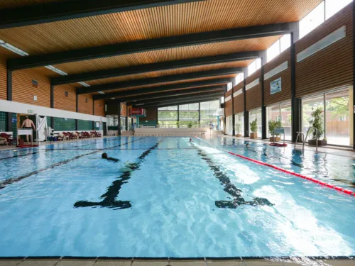 Das Schwimmerbecken des Stöckener Bads. Zwei Badende befinden sich am Beckenrand.