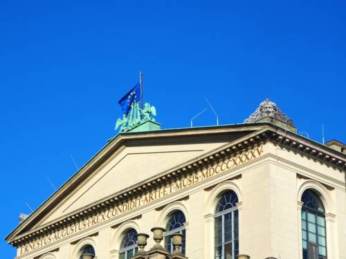 Die Europaflagge weht vor blauem Himmel auf dem Opernhaus in Hannover.