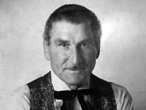 Alte Portraitaufnahme (schwarz-weiß) eines Mannes mit Oberlippenbart. Er trägt ein Hemd und darüber eine Weste.