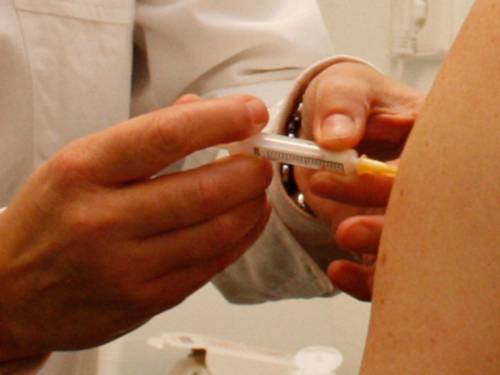 Eine Impfung in den Oberarm einer Person