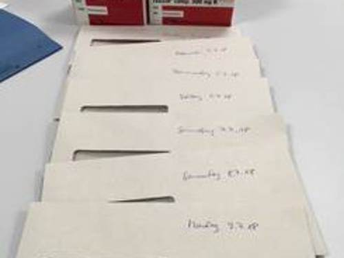 Briefumschläge mit Medikamenten, beschriftet mit Wochentag und Datum