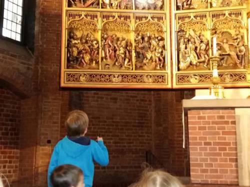 Mehrere Kinder in einer Kirche, die sich den Altarbereich anschauen.