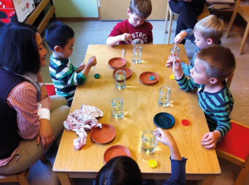 Kinder experimentieren mit Pipetten und Wasser