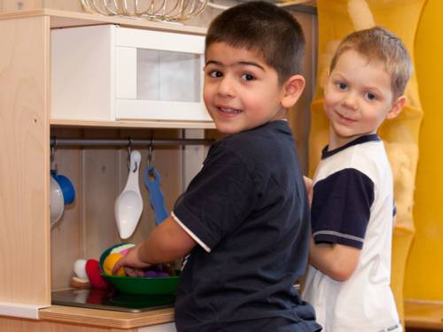 Zwei Jungen spielen in einer Spielküche