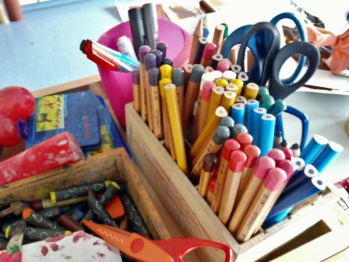 Stifte, Scheren und weiteres Material sind in einer kleinen Holzkiste.