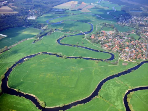 Die Leine schlängelt sich sehr kurvig durch eine Wiesenlandschaft.