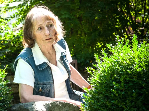Eine Frau sitzt im Garten.
