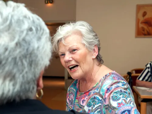 Zwei Seniorinnen sitzen beisammen und reden miteinander.