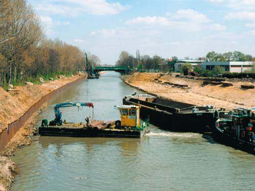Der Mittellandkanal im Bau, im Vordergrund ein Baggerschiff und ein Lastkan