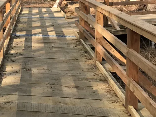 Holzsteg mit Geländer, Klopfleiste für Blindenstöcke, Aufmerksamkeitsfeldern