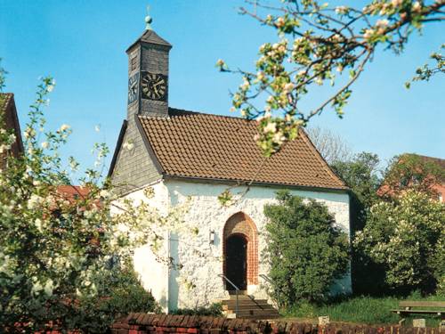 Kapelle mit weißem Mauerwerk und Schiffer gedecktem Turm