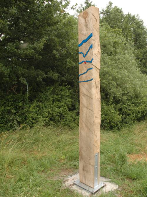 Senkrecht stehender Holzbalken mit blauen Metallwellen, die ein größeres Gewässer symbolisieren