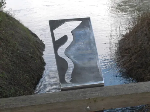 Metalltafel, die am Geländer einer Holzbrücke befestigt ist
