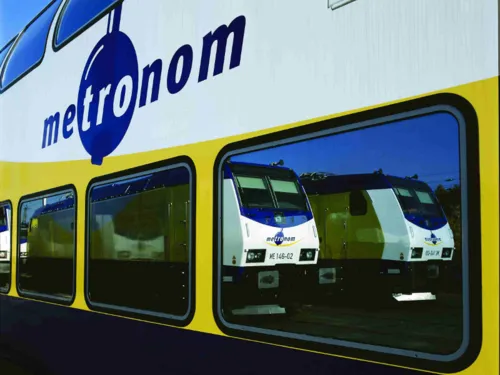 Zug in deren Fenstern sich zwei Triebwagen spiegeln.