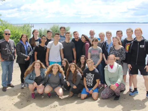 25 Personen haben sich für ein Guppenfoto am Strand des Steinhuder Meeres aufgestellt.