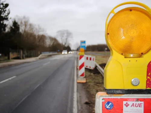 Neben einer Landstraße ist eine Baustelle, daneben ist eine Kennleuchte.