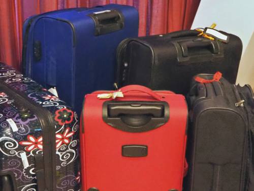 Verschiedene Koffer stehen vor einem roten Vorhang.