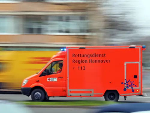 Ein Rettungswagen fährt mit Blaulicht auf einer Straße und überholt andere Fahrzeuge. Auf der Fahrzeugseite steht "Rettungsdienst Region Hannover. 112"