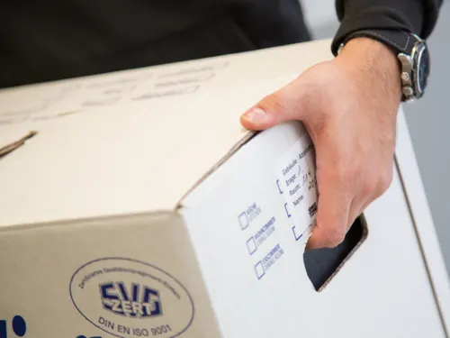 Ein Umzugskarton wird getragen.
