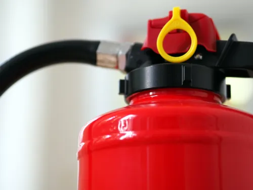 Oberer Bereich eines Feuerlöschers (Schaumlöscher, Brandklassen A und B) mit Schlauch und Sicherungseinrichtung.