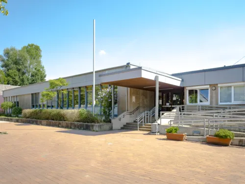 Ein Treppenaufgang und eine Rampe führen in das Flachgebäude der Grundschule Tegelweg.