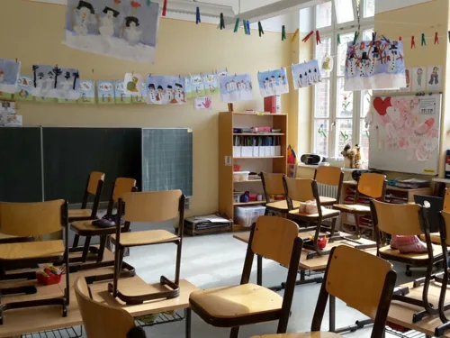 Blick in ein Klassenzimmer, das mit den Zeichnungen von Schülerinnen und Schülern geschmückt ist