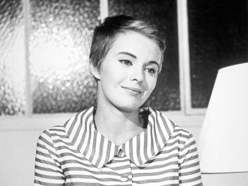 Das Bild zeigt eine junge Frau in einem gestreiften Kleid.