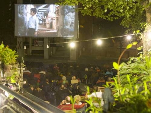 Menschen vor einer Open Air Kino-Leinwand