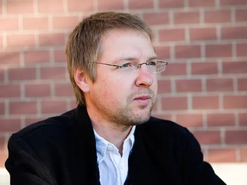Portrait von Christian Lehnert vor einer roten Backsteinwand