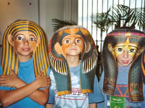 Drei Kinder hinter ägyptischen Masken. 