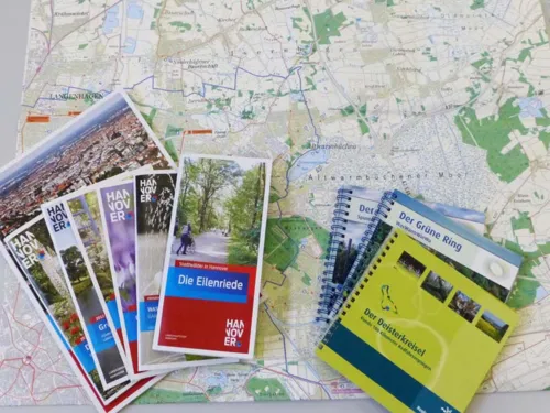 Brosch&uuml;ren und Kartenmaterial sind auf einer Landkarte ausgebreitet