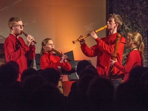 Vier junge Menschen spielen als Blockflötenquartett vor einem Publikum